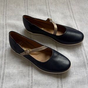 Clarks Helina Amo Mary Jane flat in navy blue leather with a gold-tone strap.